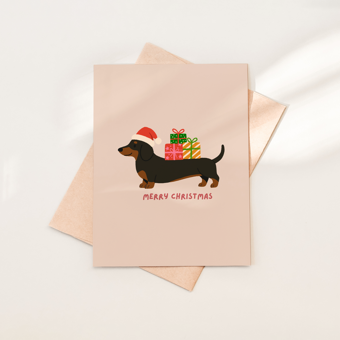 Christmas-themed greeting card with a dachshund and presents on a beige background